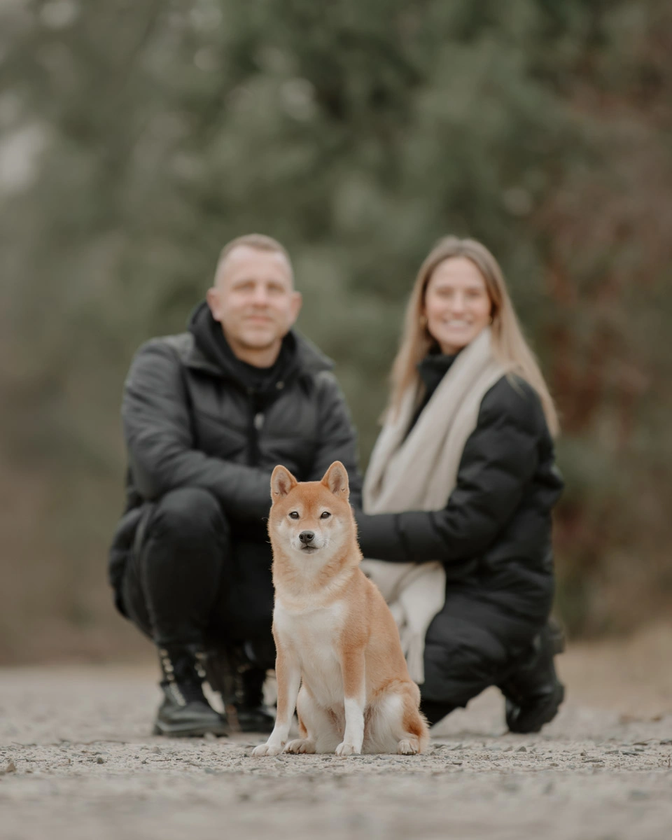 Bei einem Fotoshooting posiert ein Hund gemeinsam mit seinen Menschen auf einem Weg